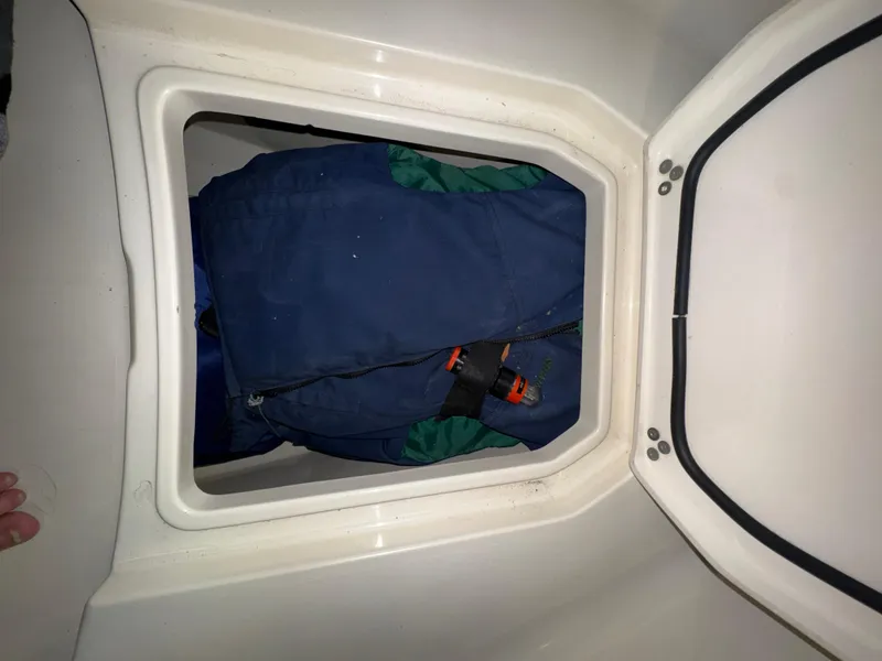 Slide: The Image of Storage compartment in a 2016 Scout 255 LXF boat with life jackets inside. - 46