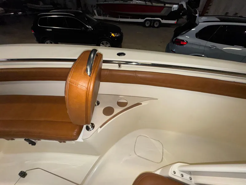 Slide: The Image of 2016 Scout 255 LXF boat interior with brown leather seating and cup holders. - 47