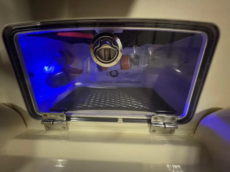 Slide: The Image of Storage compartment with blue lighting in a 2016 Scout 255 LXF boat. - 48