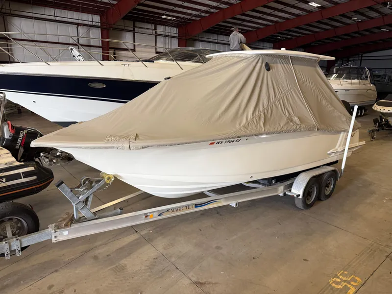Slide: The Image of 2016 Scout 255 LXF boat covered on trailer in indoor storage. - 5