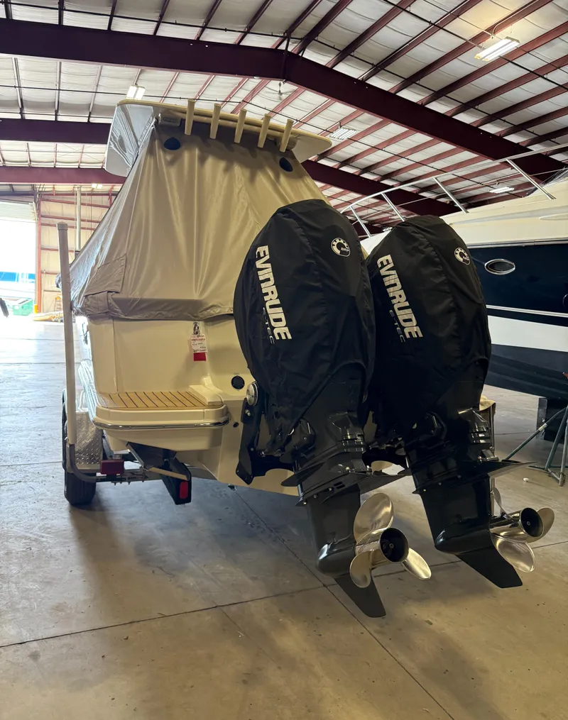Slide: The Image of 2016 Scout 255 LXF boat with twin Evinrude engines in a storage facility. - 7