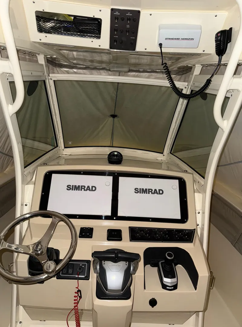 Slide: The Image of 2016 Scout 255 LXF boat dashboard with dual Simrad displays and steering wheel. - 9