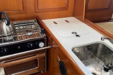 Slide: The Image of Compact kitchen in 2006 Beneteau Oceanis Clipper 323 yacht with stove, sink, and wooden cabinetry. - 10