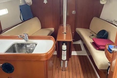Slide: The Image of Interior of 2006 Beneteau Oceanis Clipper 323 sailboat with wooden finish and seating area. - 14