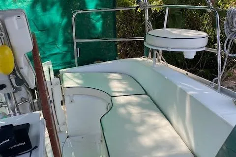 Slide: The Image of 2006 Beneteau Oceanis Clipper 323 cockpit with cushioned seating and green backdrop. - 15