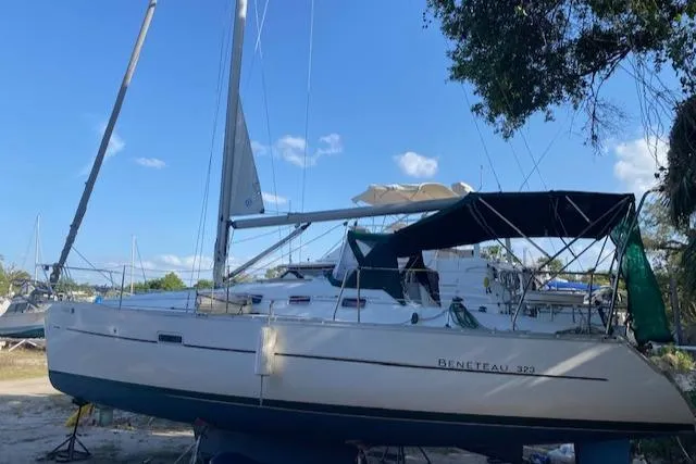 Slide: The Image of 2006 Beneteau Oceanis Clipper 323 sailboat on land, blue sky background. - 5