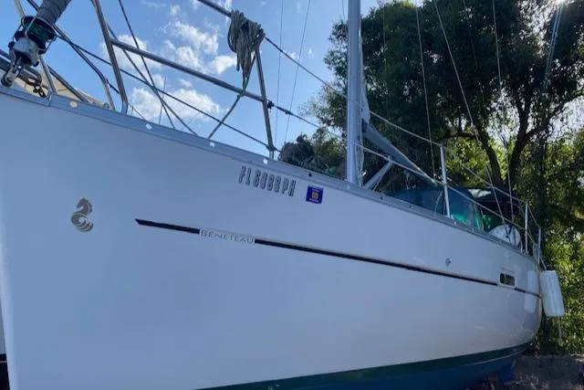 Slide: The Image of 2006 Beneteau Oceanis Clipper 323 sailboat docked, side view with trees and sky background. - 7