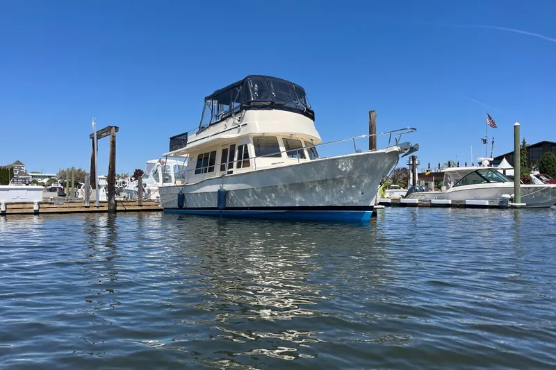 Slide: The Image of 2005 Mainship 400 Trawler docked in a marina under clear blue skies. - 0