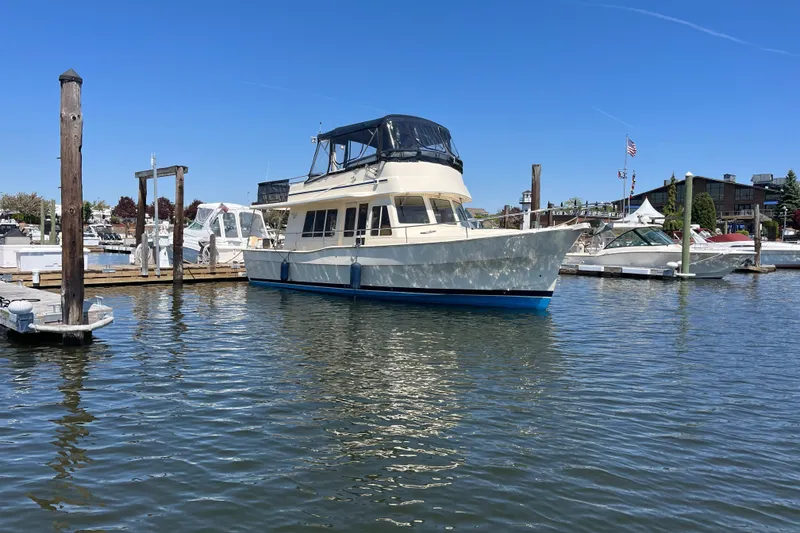 Slide: The Image of 2005 Mainship 400 Trawler docked in a marina under clear blue skies. - 1