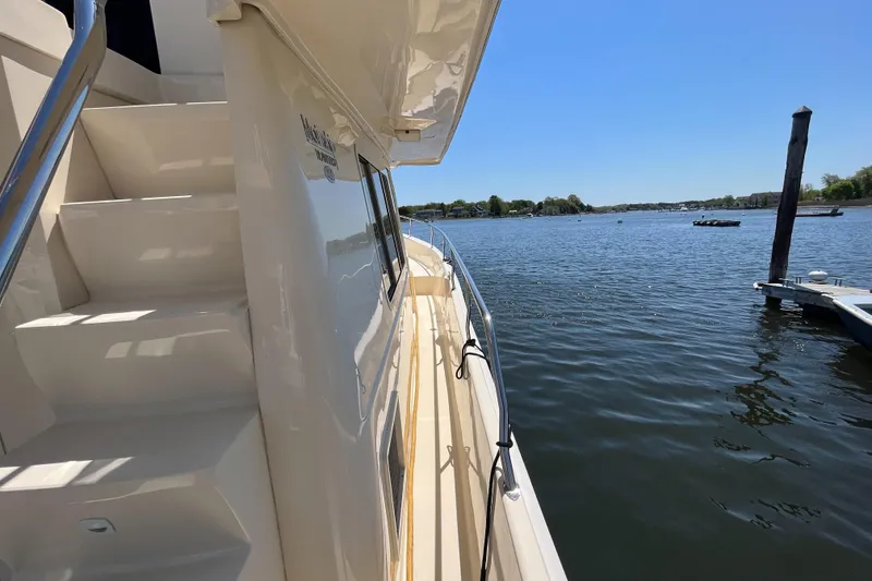 Slide: The Image of 2005 Mainship 400 Trawler on calm water, side view with clear sky. - 13