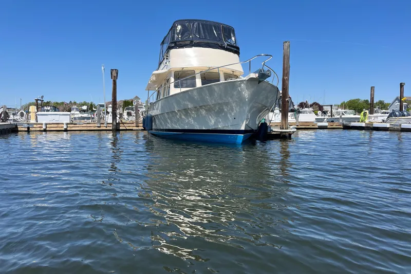 Slide: The Image of 2005 Mainship 400 Trawler docked in a marina under clear blue skies. - 2