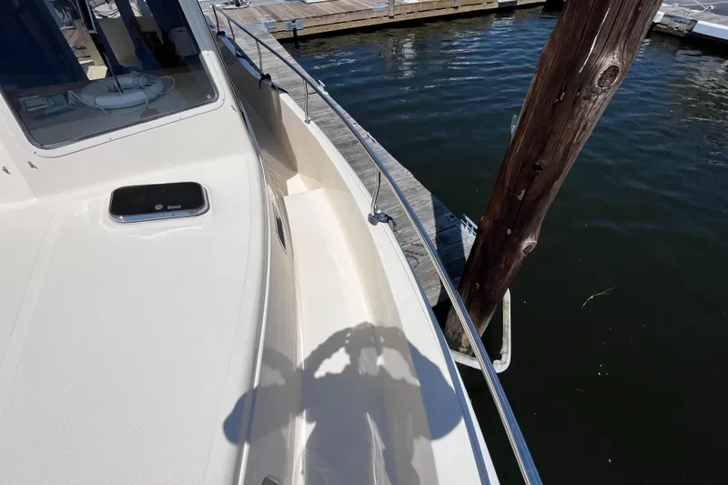 Slide: The Image of 2005 Mainship 400 Trawler docked, showing deck and railing details. - 21