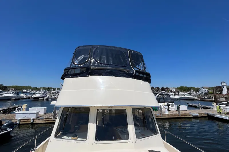 Slide: The Image of 2005 Mainship 400 Trawler docked at marina under clear blue sky. - 23