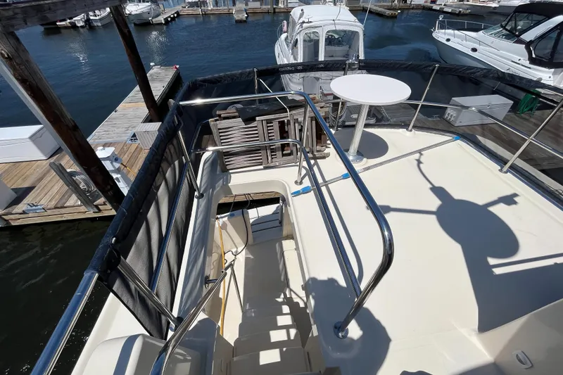 Slide: The Image of 2005 Mainship 400 Trawler deck with railing, table, and marina view. - 24