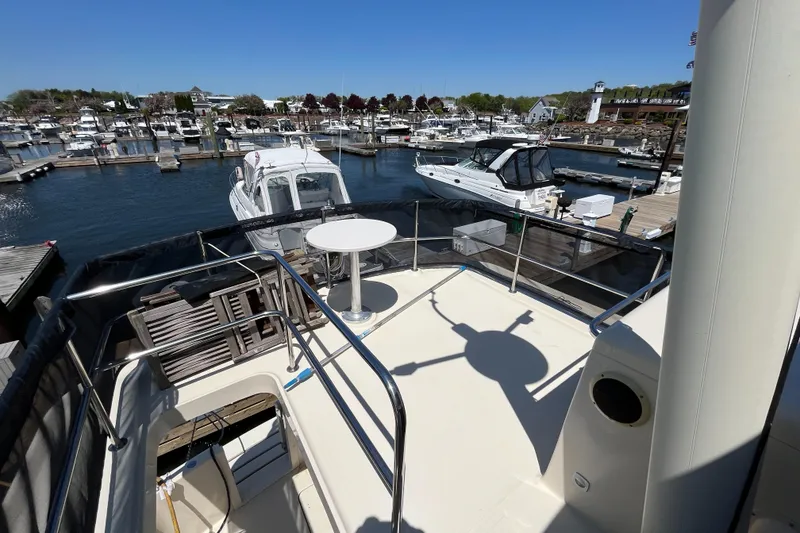 Slide: The Image of 2005 Mainship 400 Trawler docked at a marina, featuring spacious deck and seating area. - 25