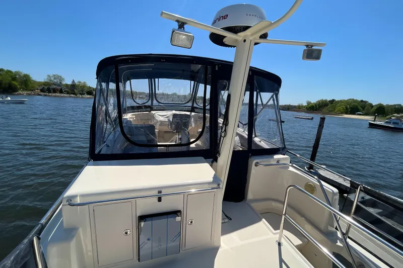 Slide: The Image of 2005 Mainship 400 Trawler on water, featuring spacious deck and enclosed cockpit. - 26
