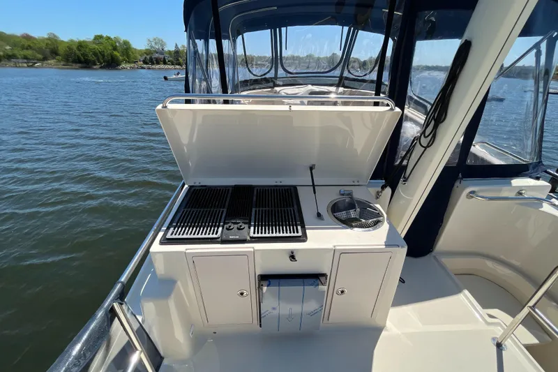 Slide: The Image of 2005 Mainship 400 Trawler outdoor kitchen with grill and sink on deck. - 27