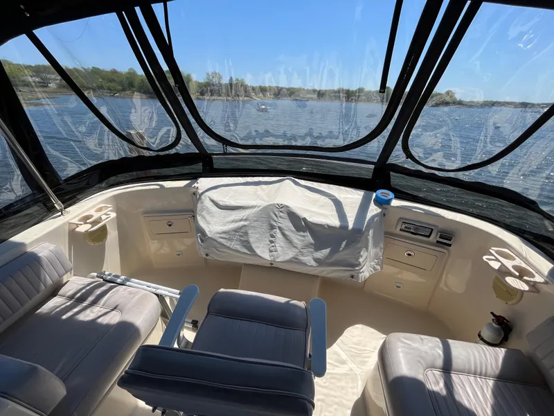 Slide: The Image of 2005 Mainship 400 Trawler helm with panoramic water view, featuring comfortable seating and controls. - 30