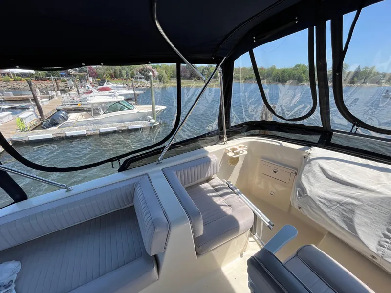 Slide: The Image of 2005 Mainship 400 Trawler interior with marina view, featuring comfortable seating and large windows. - 32