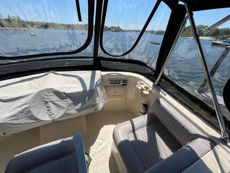 Slide: The Image of 2005 Mainship 400 Trawler interior with seating, overlooking a scenic waterfront view. - 33