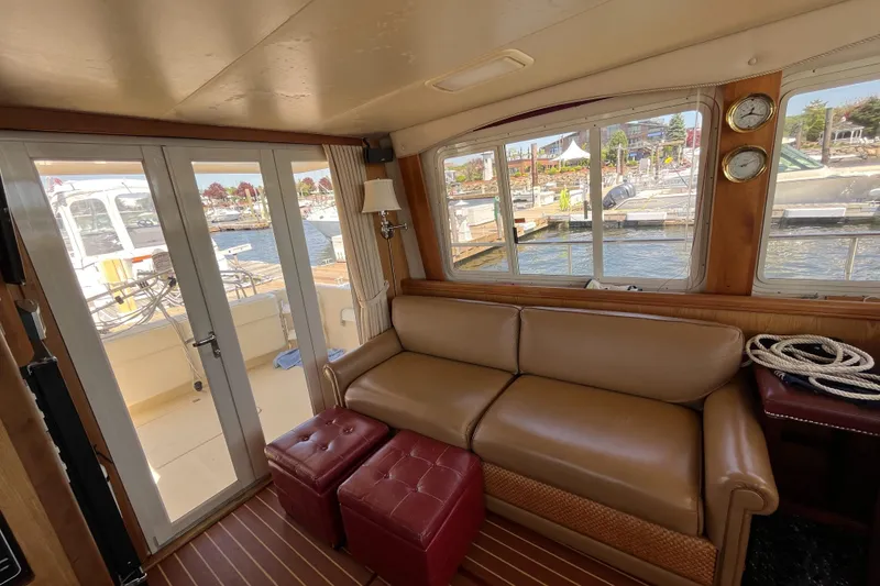 Slide: The Image of Interior of 2005 Mainship 400 Trawler with leather sofa and marina view. - 38
