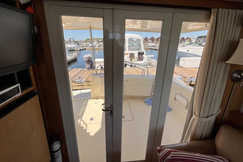 Slide: The Image of Interior view of 2005 Mainship 400 Trawler, showing glass doors leading to deck and marina. - 39
