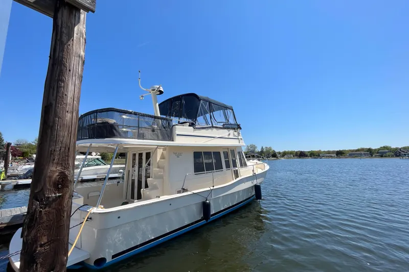 Slide: The Image of 2005 Mainship 400 Trawler docked on a sunny day by the water. - 4
