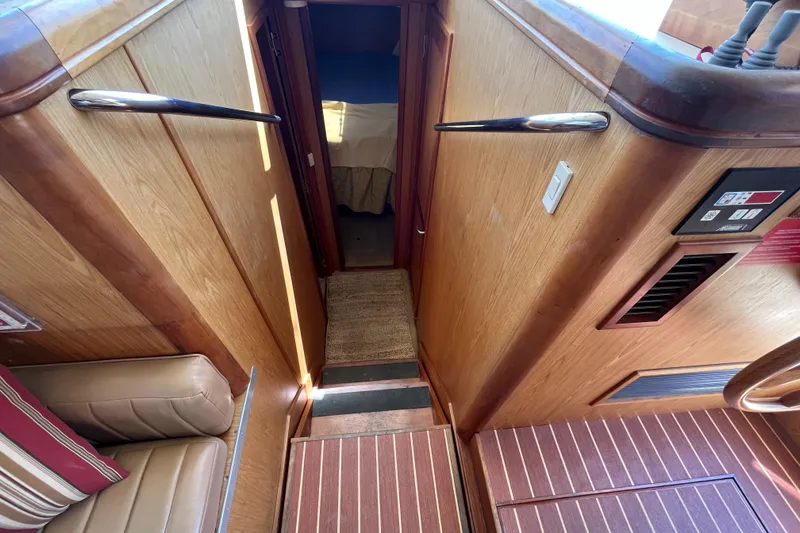 Slide: The Image of Interior view of 2005 Mainship 400 Trawler, featuring wooden paneling and a cozy cabin entrance. - 42