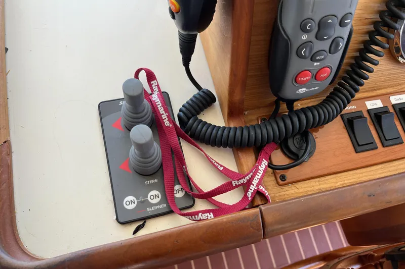 Slide: The Image of Control panel of a 2005 Mainship 400 Trawler with joysticks and communication devices. - 48