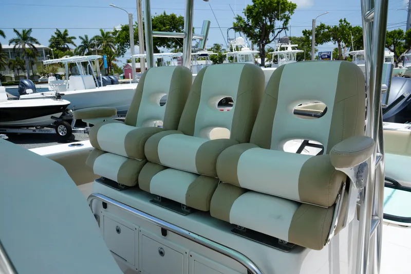 Slide: The Image of 2015 Contender 39ST boat with beige and white cushioned seating, docked under clear skies. - 13