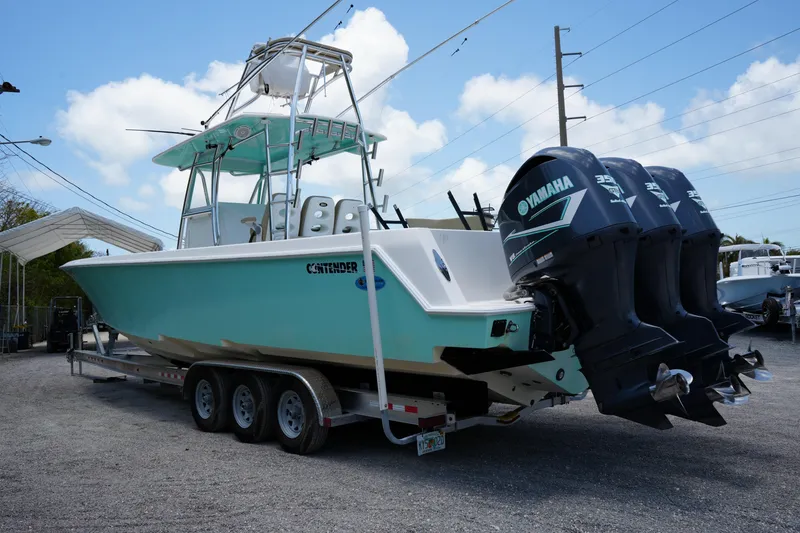 Slide: The Image of 2015 Contender 39ST boat on trailer, light blue hull, parked outdoors. - 2