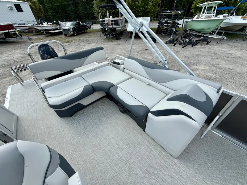 Slide: The Image of 2025 Avalon LSZ Cruise Rear Bench with stylish seating in a boatyard setting. - 12