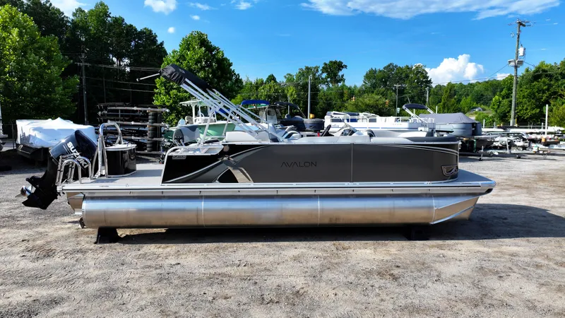 Slide: The Image of 2025 Avalon LSZ Cruise Rear Bench pontoon boat in a marina setting. - 2