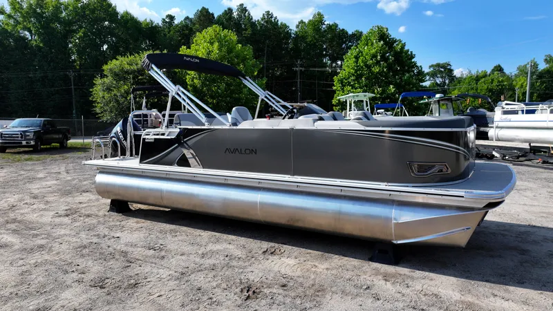 Slide: The Image of 2025 Avalon LSZ Cruise Rear Bench pontoon boat parked outdoors. - 4