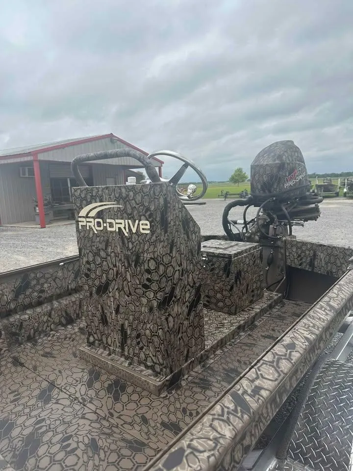 Slide: The Image of 2025 Pro-Drive 2054 X Series TD boat with camouflage design, parked outdoors. - 5