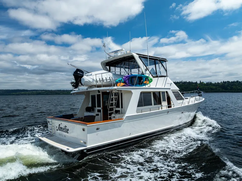 Slide: The Image of 1997 Offshore Yachts 52 Sedan cruising on open water under a partly cloudy sky. - 10