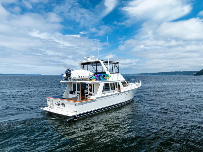 Slide: The Image of Offshore Yachts 52 Sedan, 1997 model, cruising on open water under a partly cloudy sky. - 11