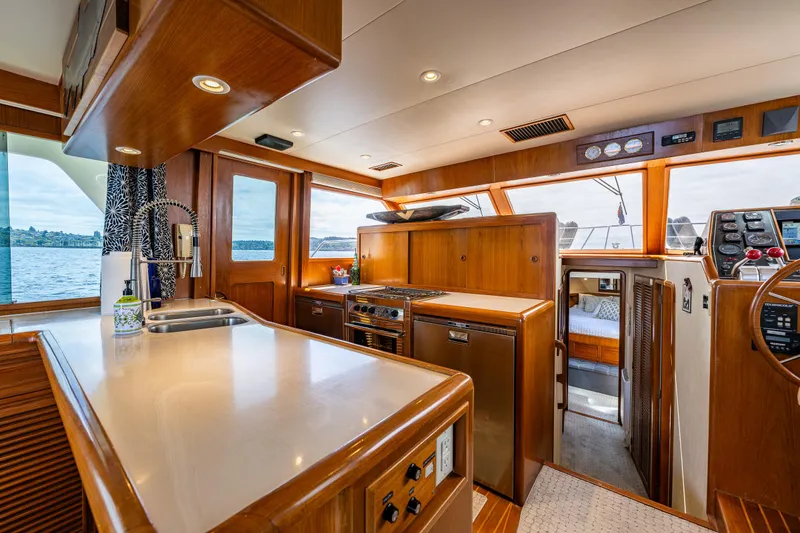 Slide: The Image of Luxurious 1997 Offshore Yachts 52 Sedan interior with modern kitchen and scenic ocean view. - 15