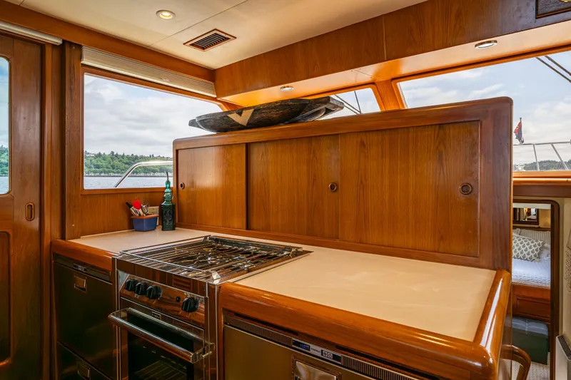Slide: The Image of Luxurious kitchen interior of 1997 Offshore Yachts 52 Sedan with wooden cabinetry and modern appliances. - 16