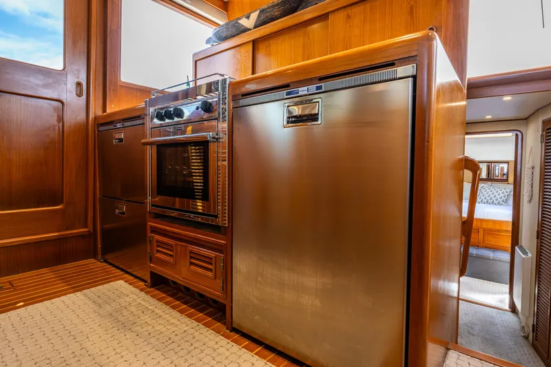Slide: The Image of Interior of 1997 Offshore Yachts 52 Sedan, featuring modern kitchen appliances and wood cabinetry. - 17