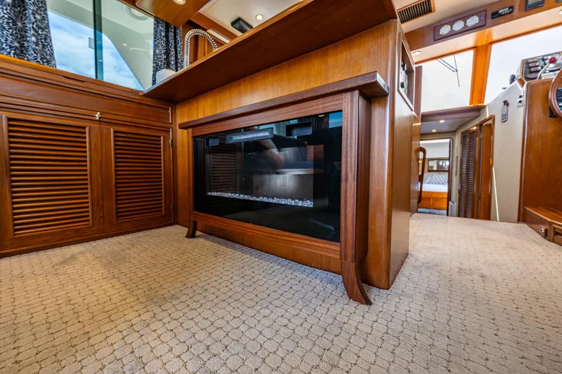 Slide: The Image of Interior of 1997 Offshore Yachts 52 Sedan with wood cabinetry and modern fireplace. - 21