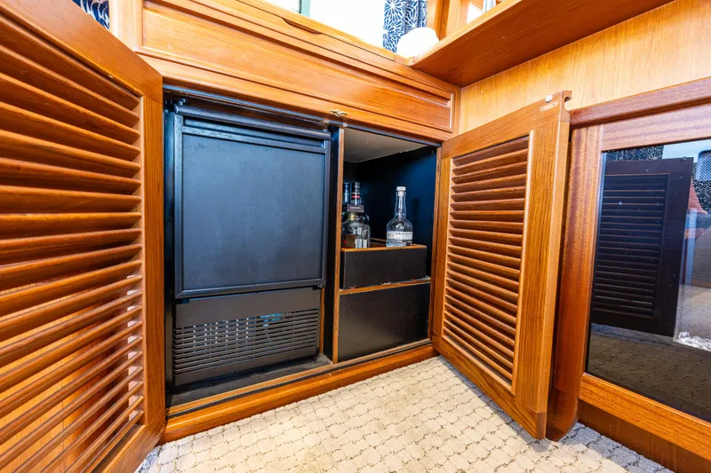 Slide: The Image of Wooden cabinet with mini fridge and liquor storage on 1997 Offshore Yachts 52 Sedan. - 22