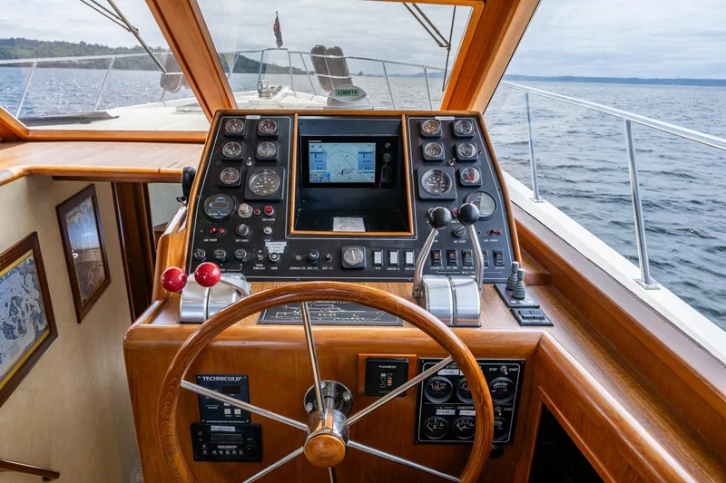 Slide: The Image of Cockpit of 1997 Offshore Yachts 52 Sedan with navigation controls and steering wheel. - 23