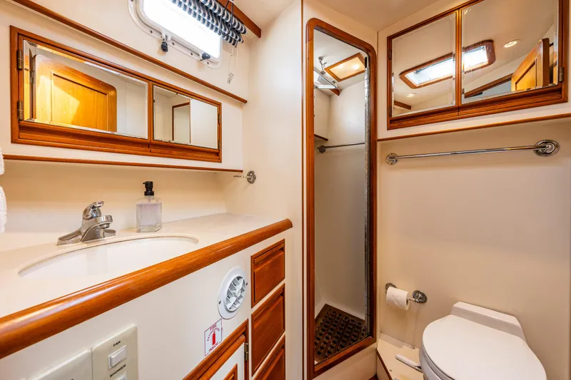 Slide: The Image of Bathroom interior of 1997 Offshore Yachts 52 Sedan, featuring sink, mirror, and shower. - 24