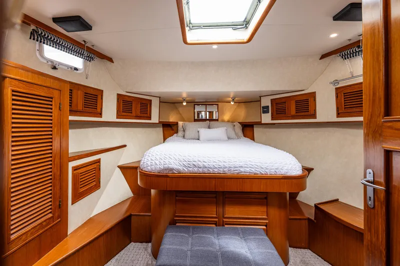 Slide: The Image of Luxurious cabin interior of 1997 Offshore Yachts 52 Sedan with wood accents and cozy bed. - 25