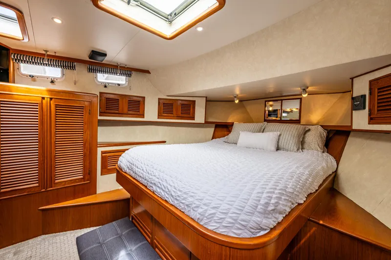 Slide: The Image of Luxurious cabin interior of 1997 Offshore Yachts 52 Sedan with cozy bed and wooden accents. - 27