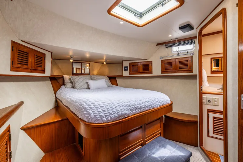 Slide: The Image of Luxurious cabin interior of a 1997 Offshore Yachts 52 Sedan, featuring a cozy bed and wooden accents. - 28