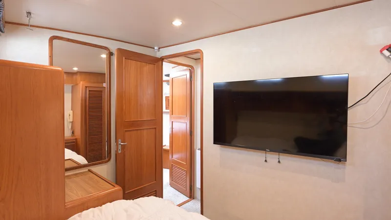 Slide: The Image of Interior of 1997 Offshore Yachts 52 Sedan with TV and wooden furnishings. - 32