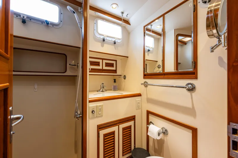 Slide: The Image of Bathroom interior of 1997 Offshore Yachts 52 Sedan with wooden accents and mirrors. - 33
