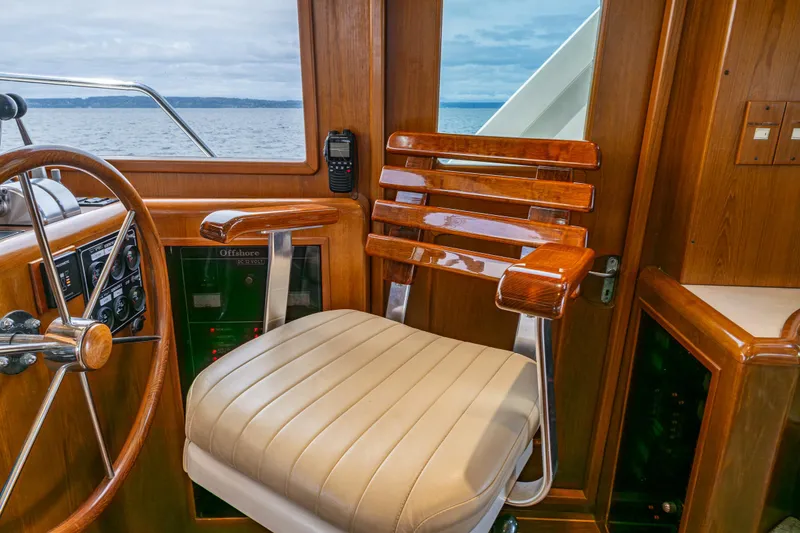 Slide: The Image of Captain's chair on 1997 Offshore Yachts 52 Sedan, featuring wood accents and ocean view. - 34